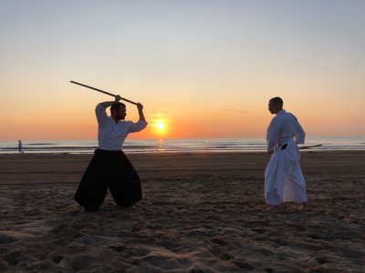 Tanguy Le Vourc'h pratiquant le sabre sur une plage avec le soleil couchant
